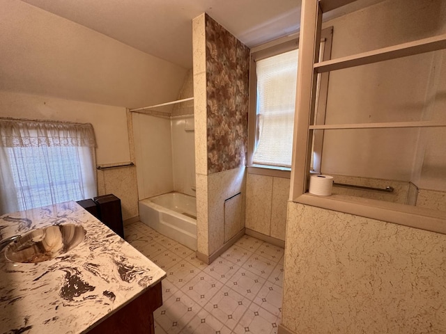 bathroom featuring vanity, shower / tub combination, and vaulted ceiling