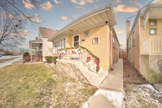 view of front of home with covered porch and a front lawn