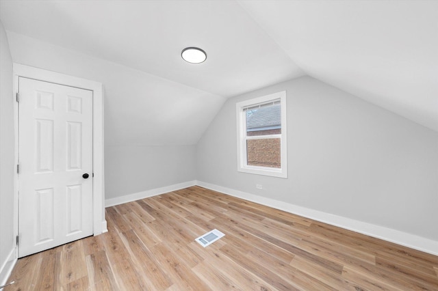 additional living space featuring light hardwood / wood-style flooring and lofted ceiling