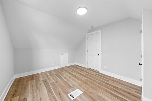 bonus room with light wood-type flooring and lofted ceiling