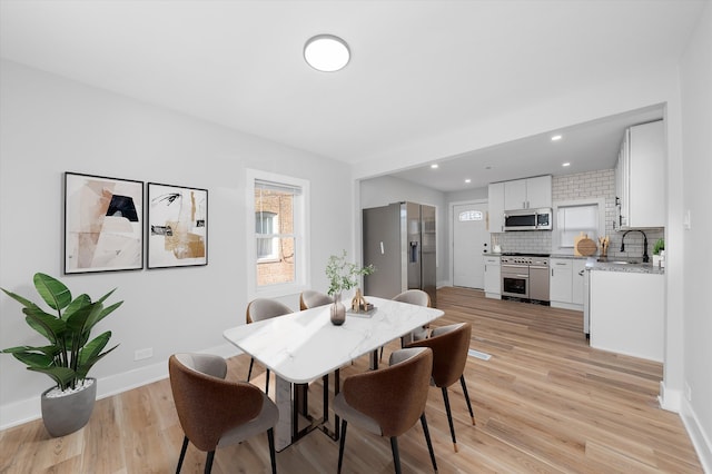 dining area featuring sink and light hardwood / wood-style flooring