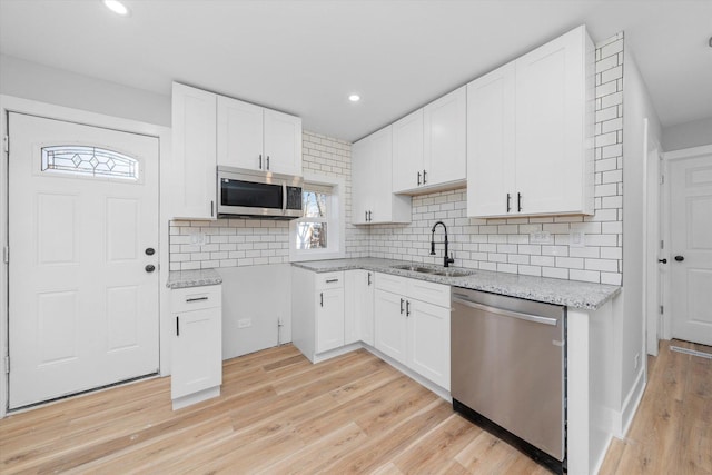 kitchen featuring decorative backsplash, sink, white cabinetry, and stainless steel appliances