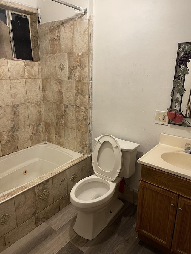 full bathroom featuring hardwood / wood-style floors, toilet, vanity, and tiled shower / bath