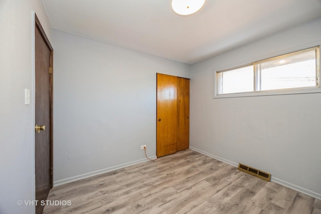 unfurnished room with light wood-style floors, baseboards, and visible vents