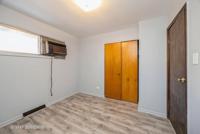 unfurnished bedroom featuring visible vents, light wood-style flooring, and baseboards