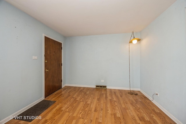 spare room with light wood-style floors, baseboards, and visible vents