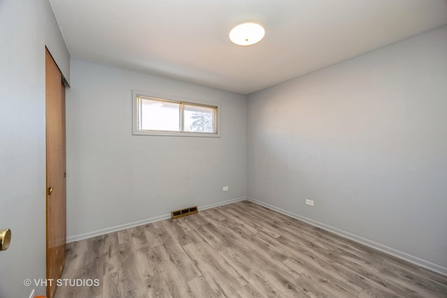 empty room featuring light wood-type flooring, baseboards, and visible vents