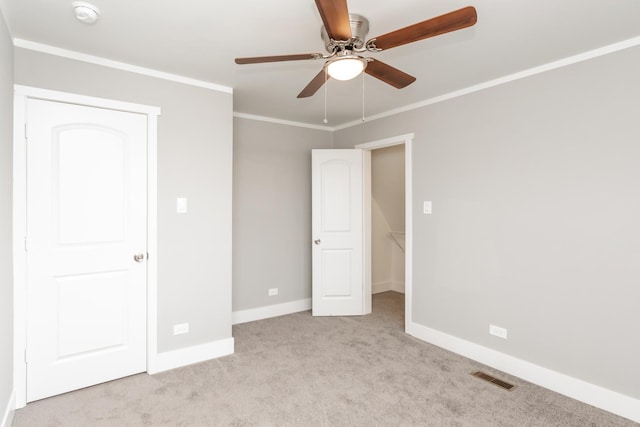 unfurnished bedroom with crown molding, ceiling fan, and light carpet