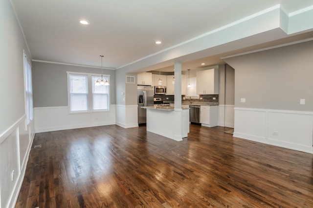 unfurnished living room with a chandelier, dark hardwood / wood-style floors, and ornamental molding