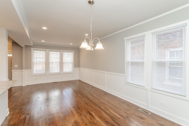 unfurnished dining area featuring a chandelier, dark hardwood / wood-style flooring, and crown molding