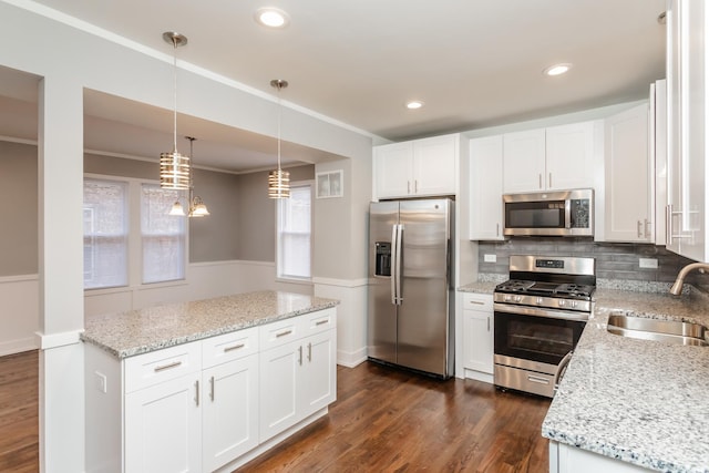 kitchen with white cabinets, appliances with stainless steel finishes, decorative light fixtures, and sink