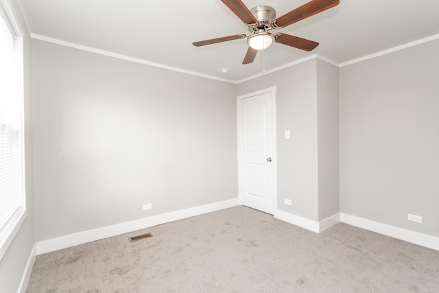 unfurnished room with ceiling fan, light colored carpet, and ornamental molding