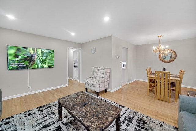 living room with hardwood / wood-style floors and an inviting chandelier