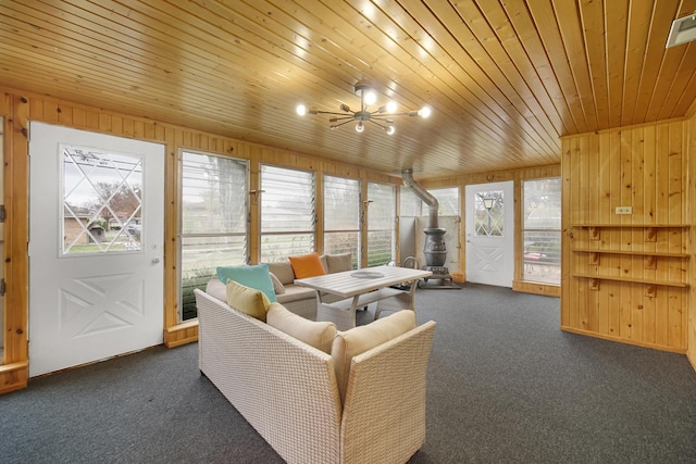 carpeted living room with wooden walls, ceiling fan, and wood ceiling