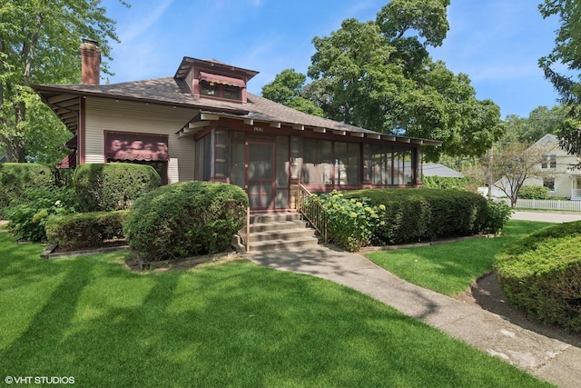 view of front of property featuring a sunroom and a front yard