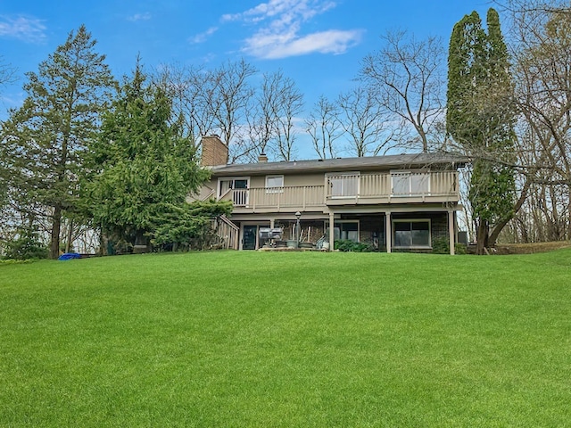 back of house with a lawn, a chimney, a wooden deck, and stairs