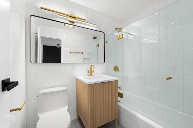 full bathroom with vanity, toilet, tile walls, and tiled shower / bath