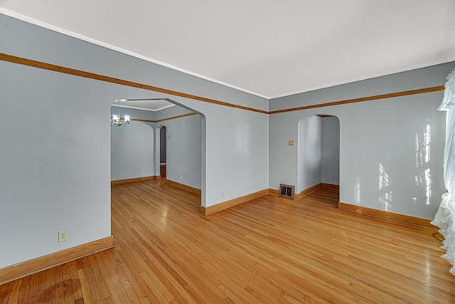 unfurnished room featuring light wood-type flooring and a chandelier