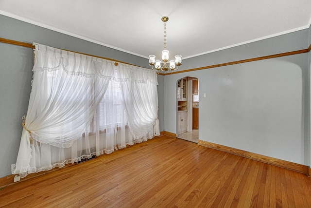 unfurnished room with hardwood / wood-style flooring and a chandelier