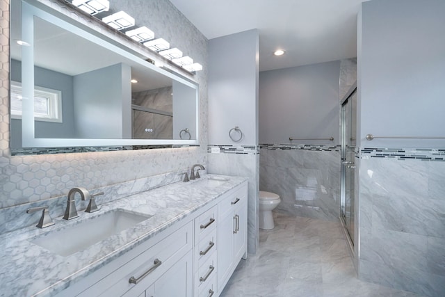 bathroom featuring walk in shower, vanity, toilet, and tile walls