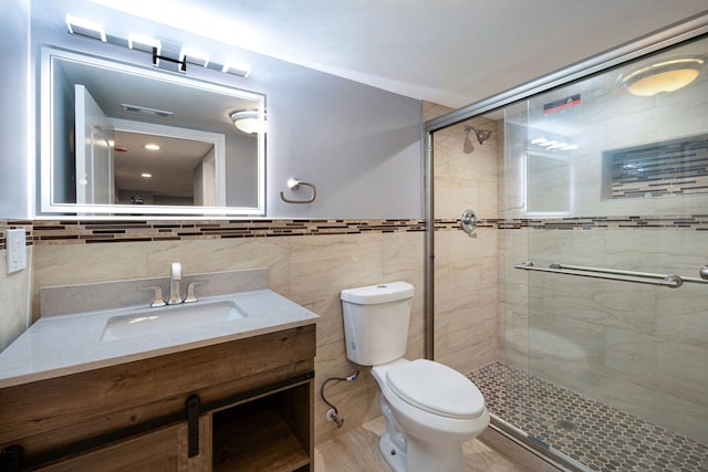 bathroom featuring vanity, an enclosed shower, tile walls, and toilet