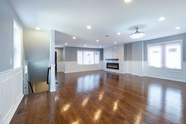 unfurnished living room with dark hardwood / wood-style floors and a high end fireplace