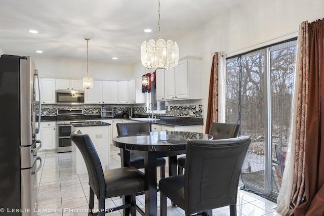 tiled dining room featuring sink and a notable chandelier