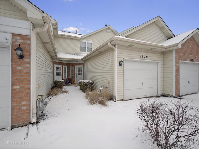 snow covered property featuring a garage