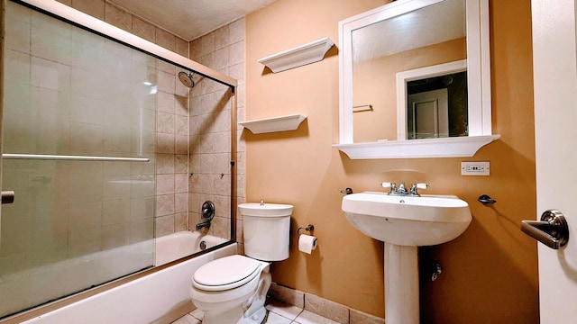 full bathroom featuring sink, a textured ceiling, tile patterned flooring, shower / bath combination with glass door, and toilet