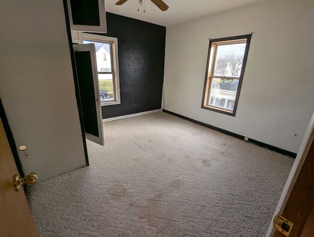 unfurnished room with ceiling fan and light colored carpet