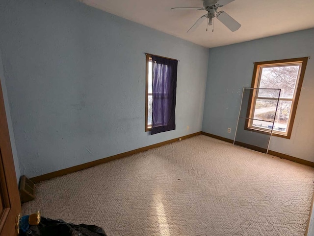 carpeted empty room featuring ceiling fan