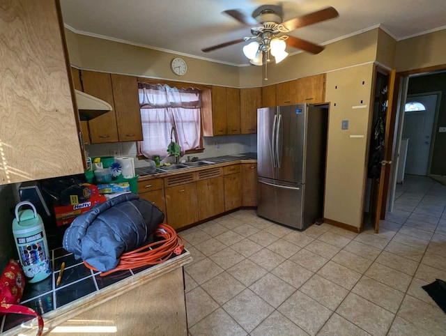 kitchen featuring ceiling fan, tile counters, sink, stainless steel fridge, and crown molding