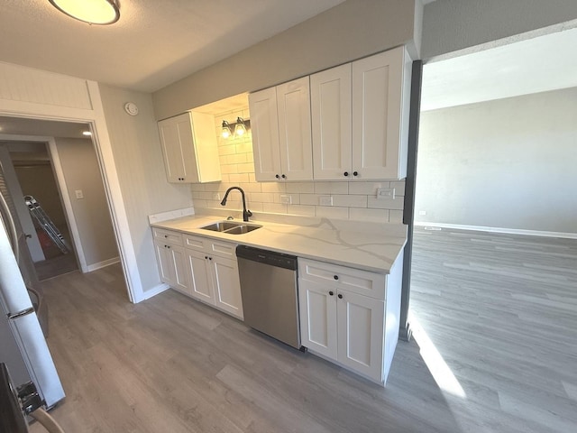 kitchen with dishwasher, sink, and white cabinets