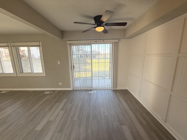 empty room featuring ceiling fan and dark wood-type flooring