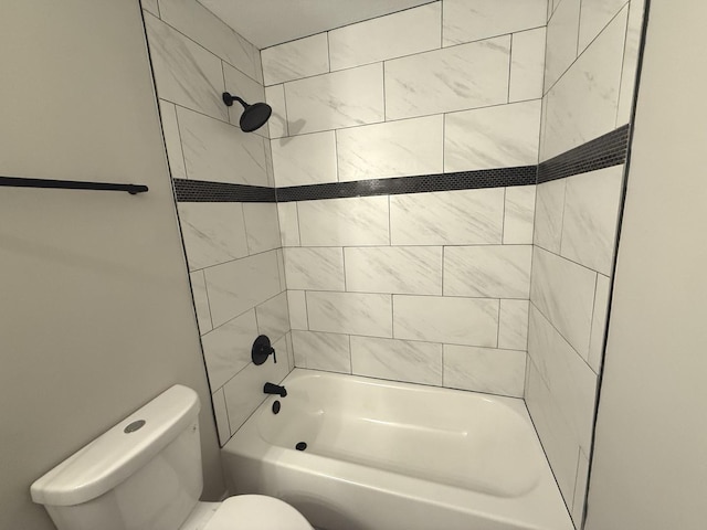 bathroom featuring toilet and tiled shower / bath