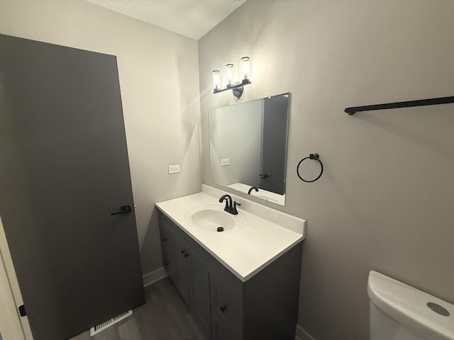 bathroom with vanity, wood-type flooring, and toilet