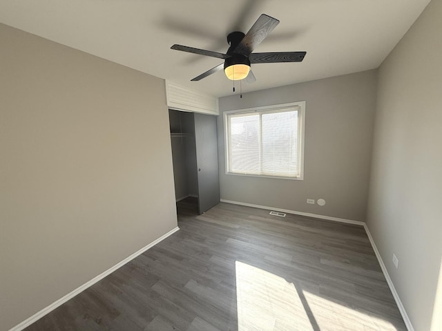 unfurnished bedroom with hardwood / wood-style flooring, a closet, and ceiling fan