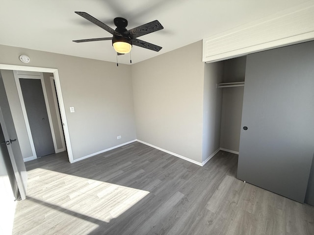 unfurnished bedroom featuring wood-type flooring, a closet, and ceiling fan