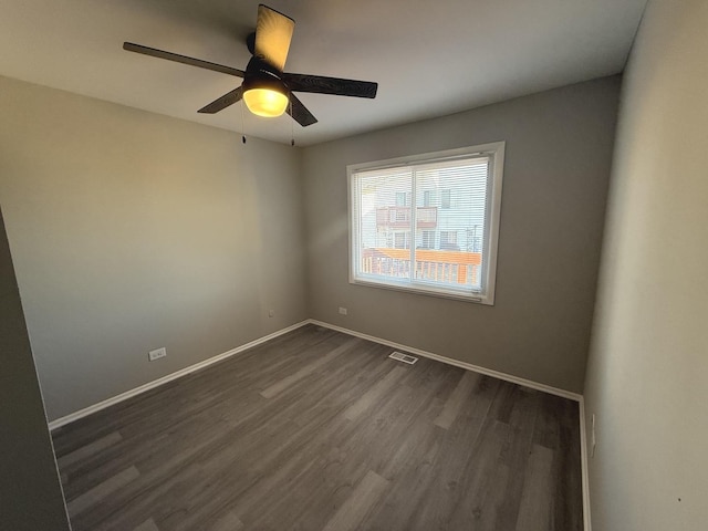 spare room featuring dark hardwood / wood-style floors and ceiling fan