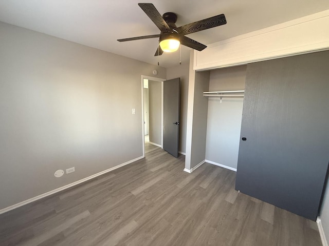 unfurnished bedroom with dark hardwood / wood-style flooring, ceiling fan, and a closet