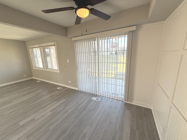 unfurnished room with ceiling fan and dark wood-type flooring