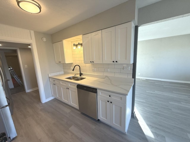 kitchen with backsplash, sink, dishwasher, white cabinetry, and fridge