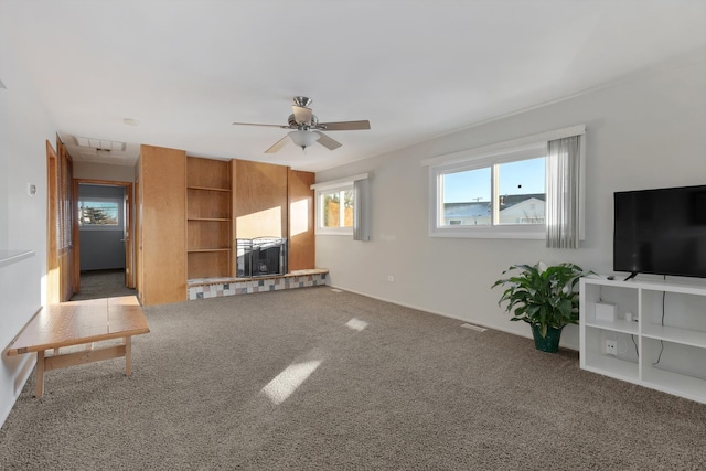 unfurnished living room with a healthy amount of sunlight, ceiling fan, and carpet floors