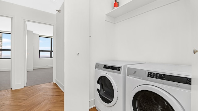 washroom with light parquet floors and independent washer and dryer