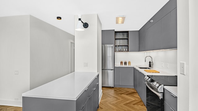 kitchen featuring gray cabinetry, light parquet flooring, and appliances with stainless steel finishes