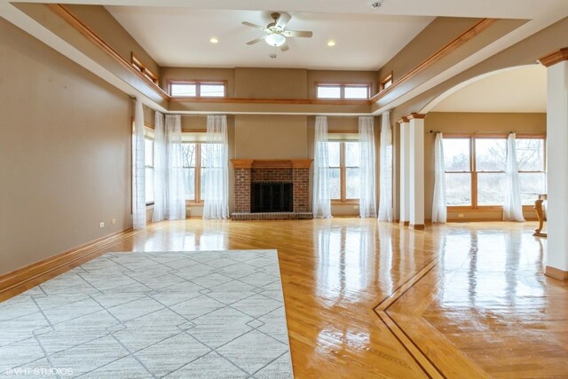 spare room featuring a tray ceiling, ornate columns, crown molding, and a chandelier