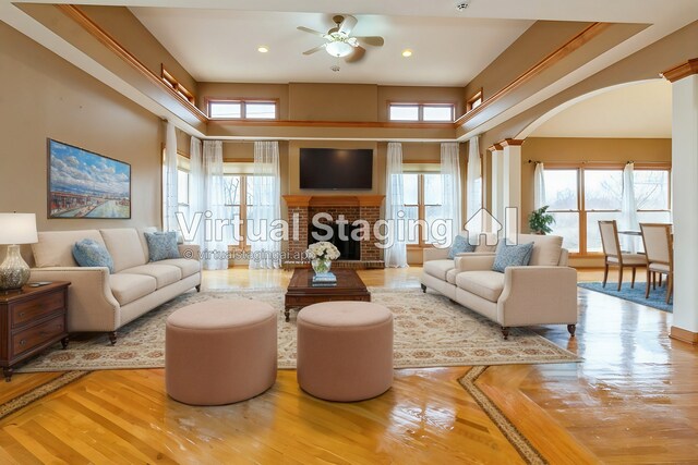 office area with an inviting chandelier, a raised ceiling, light wood-type flooring, ornamental molding, and decorative columns