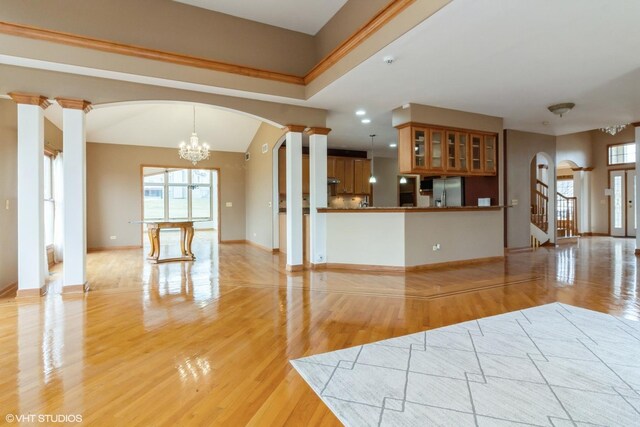 kitchen featuring a chandelier, light brown cabinetry, light wood-type flooring, and ornamental molding