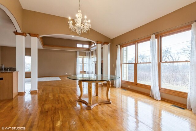 living room with hardwood / wood-style floors, ceiling fan with notable chandelier, and a healthy amount of sunlight