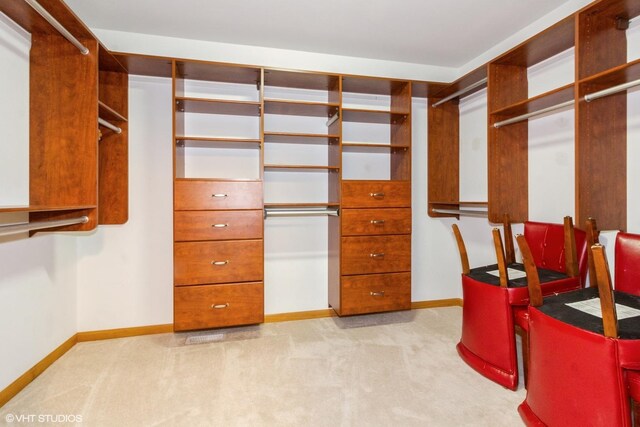 unfurnished sunroom featuring ceiling fan, vaulted ceiling with skylight, and a baseboard heating unit